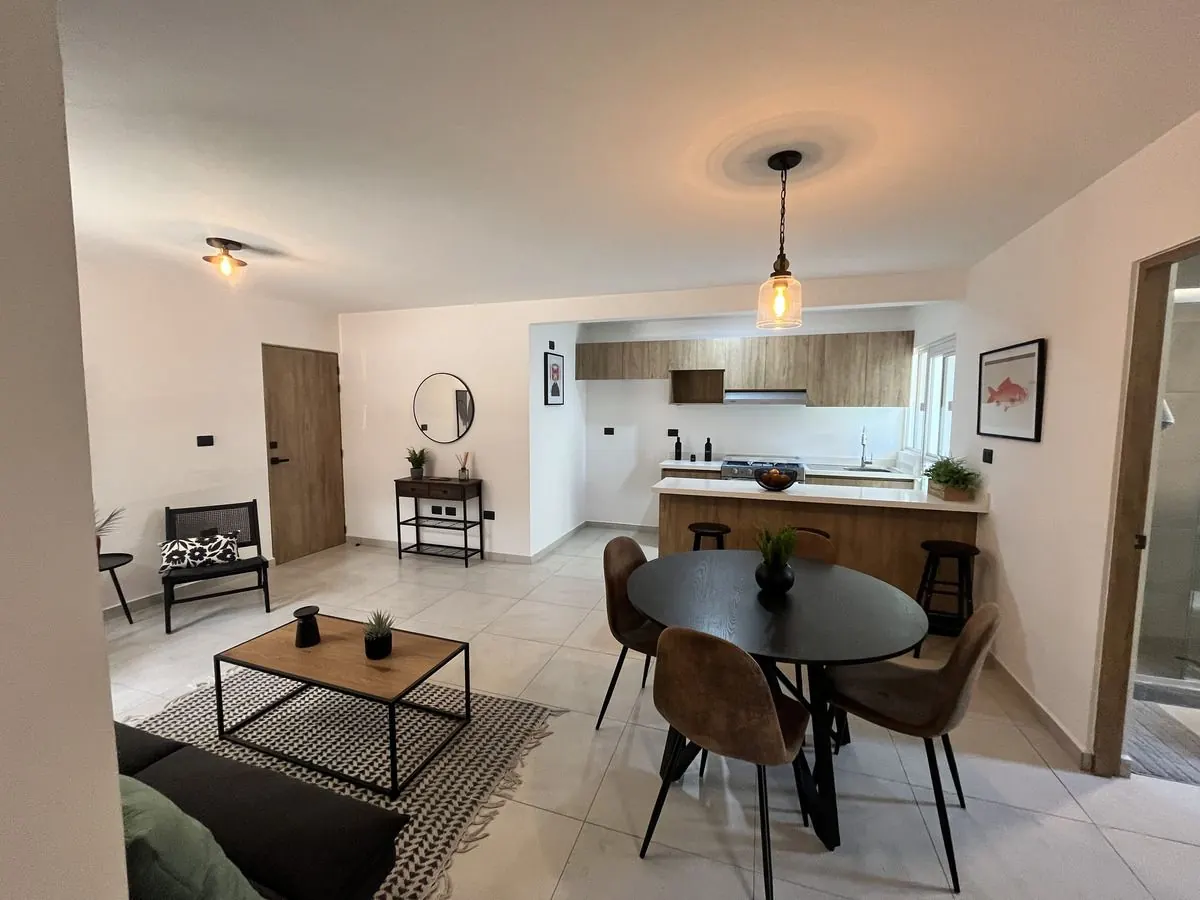 Sala, comedor y cocina integrados del departamento Nogal 1 de 74 m² en El Refugio, Querétaro